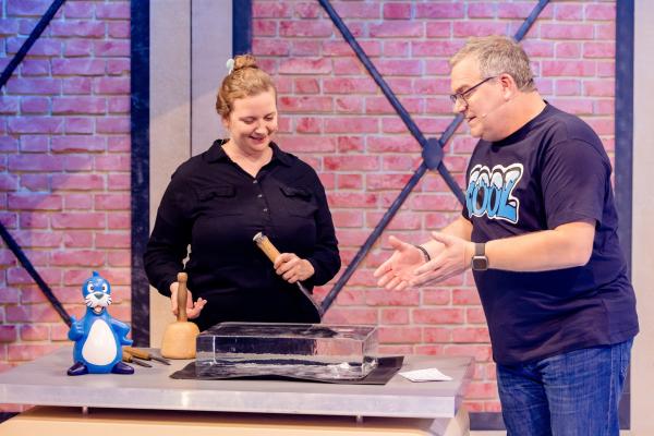 Bild 1 von 4: Eisbildhauerin Lea Diehl zeigt Elton, was sie aus gefrorenem Wasser meißeln kann.