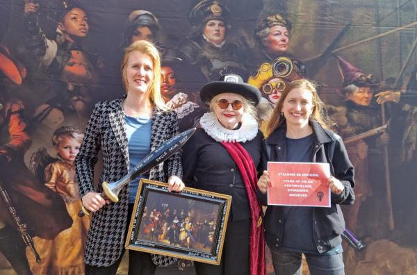 Bild 1 von 4: Rembrandts ?Nachtwache? wird von Frauen abgelöst: Dunya Verwey (Mi.) und Sia Hermanides (re.) überreichen Amsterdams stellvertretender Bürgermeisterin Melanie van der Horst (li.) ein Schwert und das Frauenbild ?Kraftwache?.