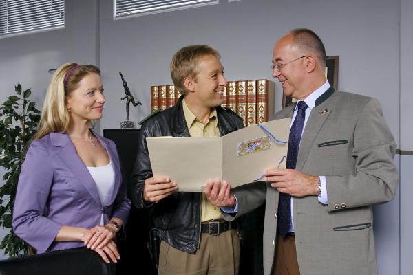 Bild 1 von 3: Polizeichef Achtziger (Alexander Duda, r.) und Controllerin Ortmann (Diana Staehly, l.) haben eine Überraschung für Mohr (Max Müller, M).