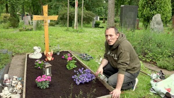 Bild 1 von 3: Florian widmet sich mit seiner ältesten Tochter Lea der Grabpflege.