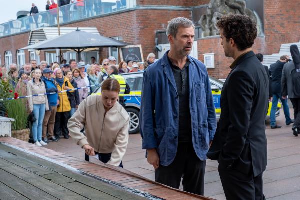 Bild 1 von 15: Weinhändler und Tanzlehrer Ferdinand Waller (Matthias Matschke, M.) beschwert sich bei Hinnerk Feldmann (Oliver Wnuk, r.) , dass seine Tangoveranstaltung durch den Toten im Publikum abgesagt werden musste. Und auch darüber, dass Hinnerk sich bei der Vorbereitung und Durchführung des Wettbewerbs mehr hätte engagieren sollen - wie Leonie (Lea Zoë Voss, l.) zum Beispiel.