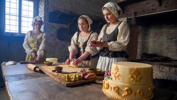 Bild 1 von 15: Das Gesinde fertigt die bunte Marzipandekoration für die Festtagstorte an.