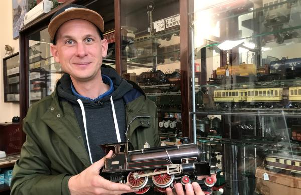 Bild 1 von 1: Die Aura alter Blech-Eisenbahnen und Puppen weckt die Sehnsucht nach einer heilen Welt. Mindestens zu Weihnachten wurden die schönsten Stücke vom Dachboden geholt und ergänzt. Nichts kam weg. Darum schlummert auch heute noch vieles in Museen und bei privaten Sammlern. Einige dieser Menschen lernen wir näher kennen. Was sie eint, ist ungetrübte kindliche Leidenschaft. - Daniel Fleischhacker sammelt Blech-Eisenbahnen.