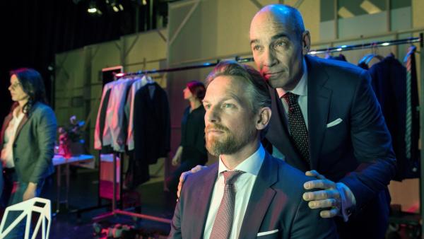 Bild 1 von 4: Der Vorstandsvorsitzende Robert Khano (Jean-Marc Barr, r.) schwört Gabriel Fenger (Barry Atsma, l.) auf die abgesprochenen Vorhaben während der Aktionärsversammlung ein. Doch kann er sich tatsächlich auf den Investmentchef verlassen?