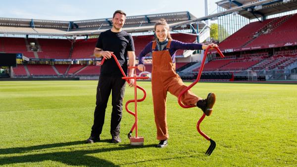 Bild 1 von 1: Marina hilft Greenkeeper Stefan den Fußballplatz im Stadion auszubessern.