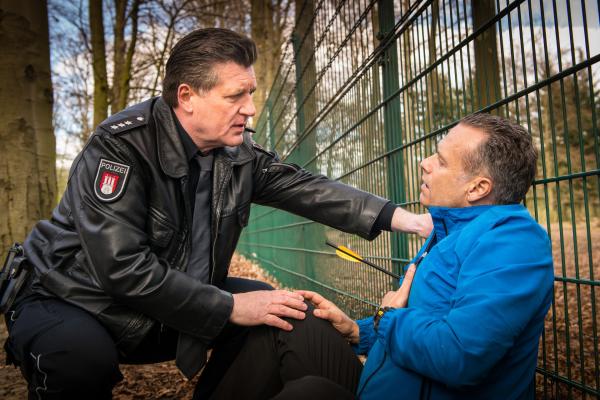 Bild 1 von 12: Hans (Bruno F. Apitz) kümmert sich um einen Jogger, der mit einer Armbrust angeschossen und schwer verletzt wurde.