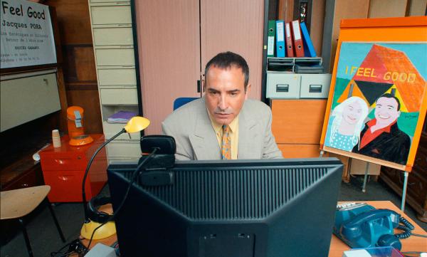 Jacques (Jean Dujardin) arbeitet im Büro an seiner Geschäftsidee, mit der er reich werden will. Er will Schönheitschirurgie zum billigen Preis anbieten.