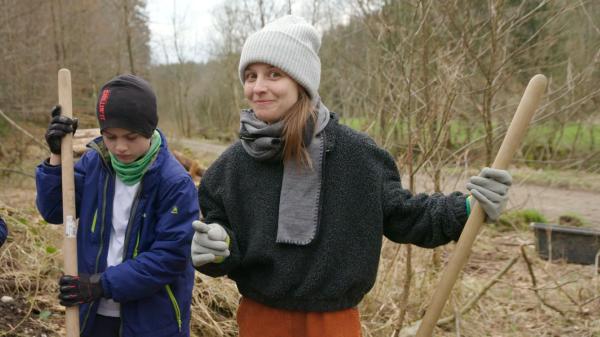 Bild 1 von 2: Marina hilft einer Schüler AG Löcher für Gelbbauchunken zu graben.