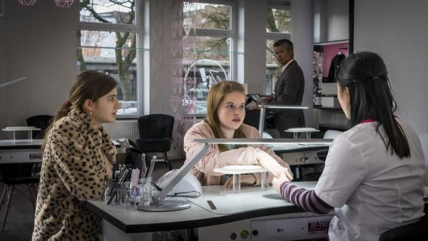 Bild 1 von 4: Lou (Luna Winter, li.) und Pippa (Elyza Silber, 2.v.li.) versuchen, mit Linhs Freundin Mai (My Dam, re.) Kontakt aufzunehmen, doch Nagelstudiochef Than (Lam Vissay) hat sie im Blick.