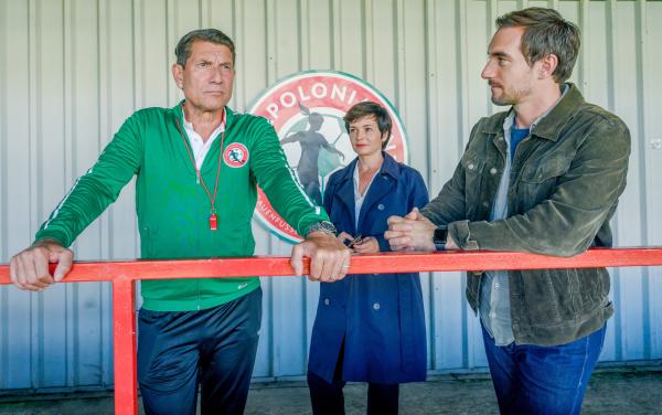 Bild 1 von 3: Trainer Toni Radax (Wolfgang Pissecker, l.) wird auf der Tribüne des Stadions von Joe (Katharina Stemberger, M.) und Ben (Daniel Gawlowski, r.) verhört. Hat er seine Gehaltserhöhung genutzt, um Geld auf die Niederlage des FC Apolonia zu setzen?