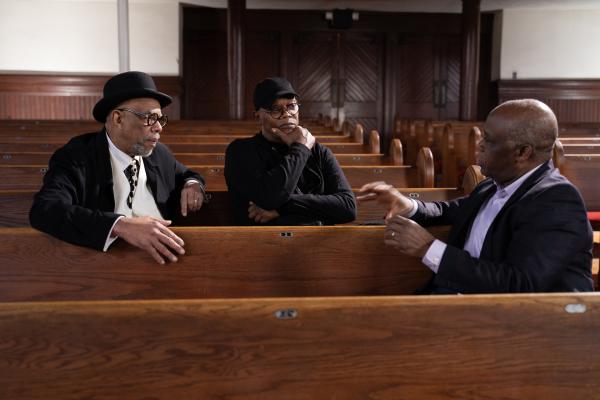 Bild 1 von 1: Samuel L. Jackson (M.) spricht mit den Musikern Clark White (l.) und Paul Kwami (r.) über ein altes Sklavenlied, das auf den Baumwollfeldern gesungen wurde.
