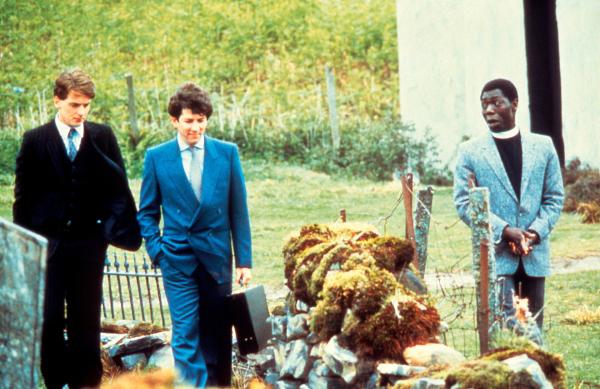 Bild 1 von 3: MacIntyre (Peter Riegert, M.) und Danny Oldsen (Peter Capaldi, l.) versuchen, den Pfarrer Macpherson (Gyearbuor Asante) vom Verkauf der Bucht zu überzeugen.