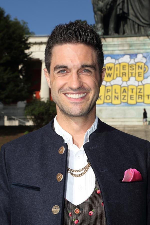 Bild 1 von 8: Moderator Dominik Glöbl begrüßt beim Wiesn-Platzkonzert am Fuße der Bavaria traditionsgemäß über 300 Musikerinnen und Musiker sowie zahlreiche Persönlichkeiten, die eng mit der Wiesn verbunden sind.