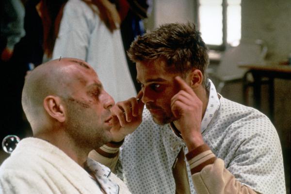 Bild 1 von 4: In der Psychiatrie trifft James Cole (Bruce Willis, li.) den verrückten Patienten Jeffrey Goines (Brad Pitt).
