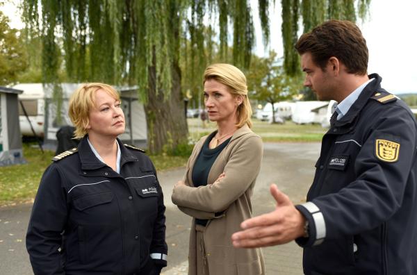 Bild 1 von 1: Christiane Fahlbusch (Astrid M. Fünderich, Mitte) gibt Kevin die Schuld am Tod ihrer Tochter und macht gegenüber Nele Fehrenbach (Floriane Daniel, links) und Jakob Frings (Max König, rechts) keinen Hehl daraus, dass sie Kevins Tod keinesfalls betrauert.