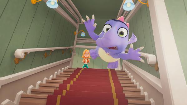 Bild 1 von 2: Sophie möchte Dino Doris unbedingt das Fliegen beibringen, doch Doris hat Schwierigkeiten und fliegt eine Treppe herunter.© KiKA/MACK Magic/Der Kinderkanal von ARD und ZDF, 2025- Honorarfreie Verwendung gemäß AGB im redaktionellen Zusammenhang mit genannter Sendung bei Nennung \
