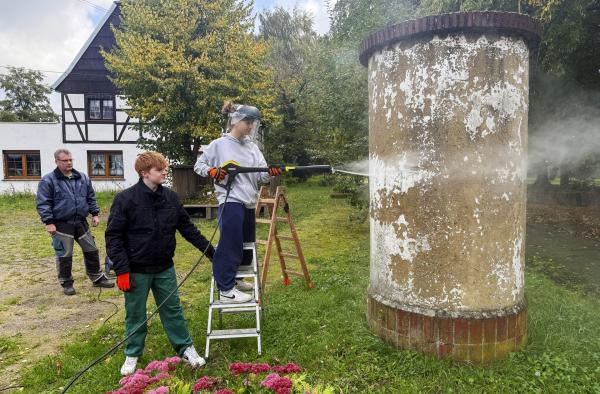 Bild 1 von 8: Pauline Diebel und Jonas Scholz säubern die alte Litfaßsäule und wollen sie mit Motiven aus dem Ort bemalen. Die Dorfbewohner sollen dabei mitmachen.