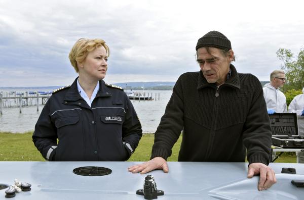 Bild 1 von 1: Nele Fehrenbach (Floriane Daniel, links) schenkt dem trauernden Vater Rainer Fehringer (Martin Feifel), ihr Gehör. Die KTU (hinten rechts) dokumentiert Unfallspuren an der Jolle.