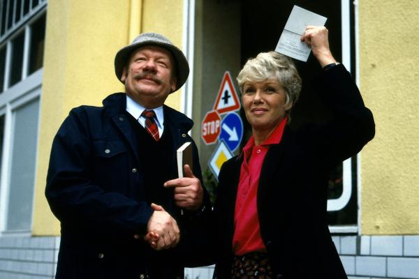 Bild 1 von 2: Geschafft - der Fahrprüfer (Wolfgang Völz) gratuliert Hannelore Wichert (Maria Sebaldt) zur bestandenen Führerscheinprüfung.