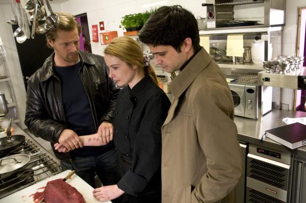 Bild 1 von 27: Sternekoch Florian Reuter liegt erschlagen im Speisesaal. Während Mick (Henning Baum, l.) und Andreas (Max Grill, r.) die Tatwaffe suchen, zerschneidet Küchenhilfe Irina (Vanessa Radmann, M.) einen frisch aufgetauten Thunfisch ...