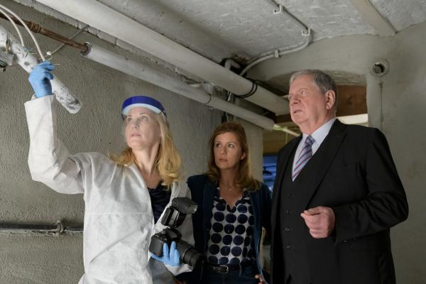 Bild 1 von 1: Dr. Judith Engel (Astrid Posner, l.), Hauptkommissarin Kerstin Klar (Fiona Coors, M.) und Oberstaatsanwalt Bernd Reuther (Rainer Hunold, r.) begutachten eine defekte Elektroinstallation im Keller von Angelika Lorenz.