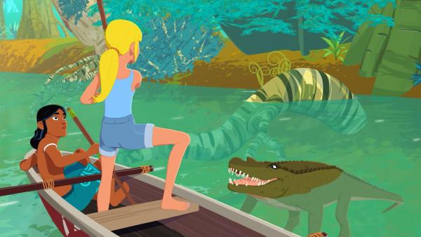 Bild 1 von 4: Auru (l.) und Clarissa (r.) wollen ein Krokodil vertreiben, das sich ihrem Ruderboot nähern will.