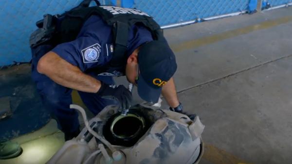 Bild 1 von 3: Ein ausgebauter Fahrzeugtank wird von einem Grenzbeamten untersucht. Der Tank zählt zu den beliebtesten Orten für den Schmuggel, da er Platz für Drogen im Wert von bis zu einer halben Million Dollar bietet.