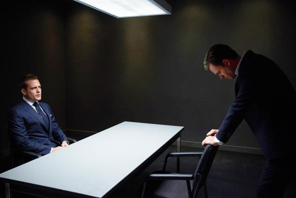 Bild 1 von 2: Harvey (Gabriel Macht, l.) versucht Mike (Patrick J. Adams, r.)  zu helfen, dessen schlimmster Albtraum Realität wurde. Er wurde wegen Betrugs verhaftet und ausgerechnet die knallharte Staatsanwältin Anita Gibbs ist für den Fall zuständig.