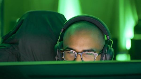 Bild 1 von 6: Game-Trainer Ron Manjang schaut auf seinem Bildschirm seinen Schützlingen beim Training in einem Videospiel zu und gibt ihnen über das Headset Anweisungen für eine taktischere Spielweise.