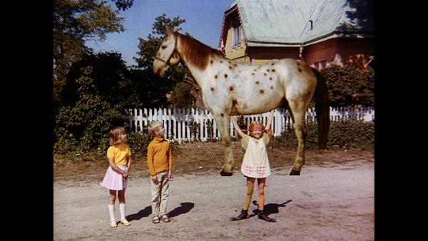 Bild 1 von 5: Pippi (Inger Nilsson, r.) lässt ihre Kräfte spielen. Tommy (Pär Sundberg, M.) und Annika (Maria Persson, l.) schauen überrascht zu.