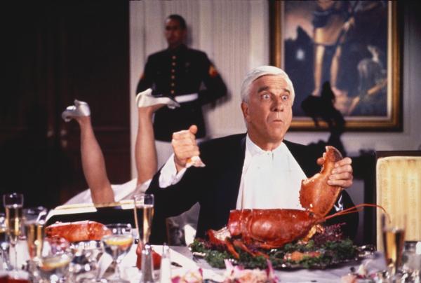 Bild 1 von 8: Als Belohnung für die Erschießung des 1000. Drogendealers erhält Lt. Frank Drebin (Leslie Nielsen, l.) eine Einladung zum Abendessen beim Präsidenten. Mit seinen schlechten Tischmanieren verärgert er Frau Präsident ...