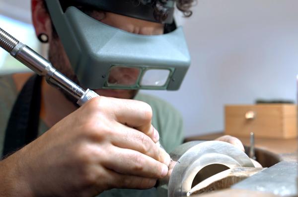 Bild 1 von 1: Damit die Löcher am Ausguss millimetergenau gebohrt werden, trägt der Silberschmied eine Lupenbrille.