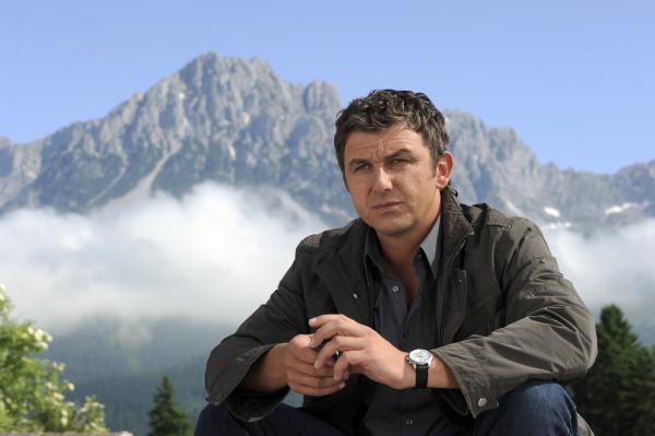 Bild 1 von 1: Nachdenklich sitzt der Bergdoktor Martin (Hans Sigl) vor seiner Praxis.