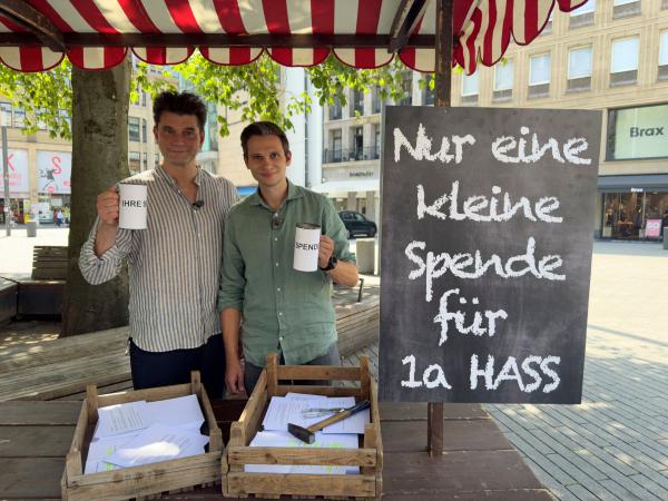 Bild 1 von 9: Lutz van der Horst (l.) und Fabian Köster(r.) in der Düsseldorfer Kö. Mit einer kleinen Aktion wollen sie helfen, Hass gegen Kommunalpolitiker zu bekämpfen.