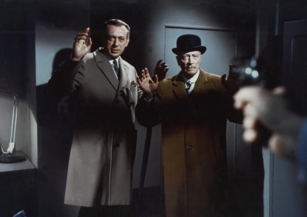 Bild 1 von 1: Inmitten der drängenden Ermittlungen zu einer Serie grausamer Mordfälle sehen sich Inspektor Perkins (Horst Tappert, l.) und Sir Arthur (Hubert von Meyerinck, r.) von Scotland Yard plötzlich einer gefährlichen Situation gegenüber, als sie von jemandem mit einer Waffe bedroht und gezwungen werden, ihre nächsten Schritte mit äußerster Vorsicht zu planen.
