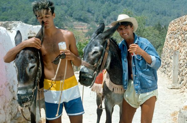 Bild 1 von 4: George Michael (re.) und Andrew Ridgeley (li.), besser bekannt als Popduo Wham!, besuchen die spanische Insel 1983. Sie drehen kurzerhand das Musikvideo zu ihrem Hit ?Club Tropicana?.
