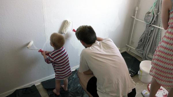 Bild 1 von 3: Papa Maik und Sohn Lennox streichen gemeinsam die Wand