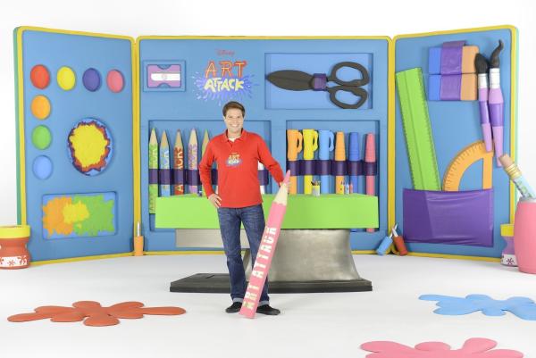 Bild 1 von 11: Stifte, Kleber, fertig, los! Das große Basteln beginnt wieder - mit brandneuen Folgen von Art Attack. Moderator Nicolás Artajo führt die kleinen Zuschauer in seine bunte Bastelwelt und verwandelt Alltagsgegenstände in tolle Kunstwerke. Er zeigt, wie man mit wenigen Hilfsmitteln wunderschöne Projekte umsetzt. Damit seine Zuschauer es ihm gleichtun können, wird jeder Handgriff genau erklärt. Schritt für Schritt zeigt Disney Art Attack, wie man aus unscheinbaren Haushaltsgegenständen wie leeren Küchenpapierrollen, Pappkartons, leeren Joghurtbechern und Zeitungspapier die tollsten Sachen zaubert. Dabei wird nicht nur die Fantasie der kleinen Zuschauer angeregt, auch die kreativen und motorischen Fähigkeiten werden gefördert. Nicolás hat sich auch für die elfte Staffel wieder einiges vorgenommen: Neben Big-Band-Instrumenten, einer Piratentaverne aus Holzstäbchen oder dreidimensionalen Hügelbildern und einem Lenker-Clown für den Roller oder das Fahrrad werden auch fliegende Topfpflanzen nachgebastelt.