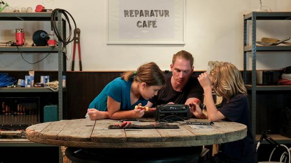 Bild 1 von 5: Im Bild: Eva und Tom reparieren gemeinsam mit dem Elektriker Johannes ein Radio.