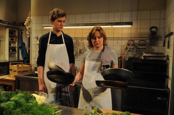 Bild 1 von 7: Patrick fühlt sich überrumpelt, als Vroni plötzlich das Kommando in der Küche übernimmt. Von links: Patrick Westenrieder (Lucas Bauer) und Veronika Brunner (Senta Auth).