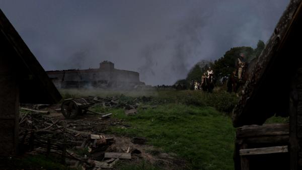 Bild 1 von 4: Eine Gruppe von Rittern reitet an einem Schlachtfeld vorbei.