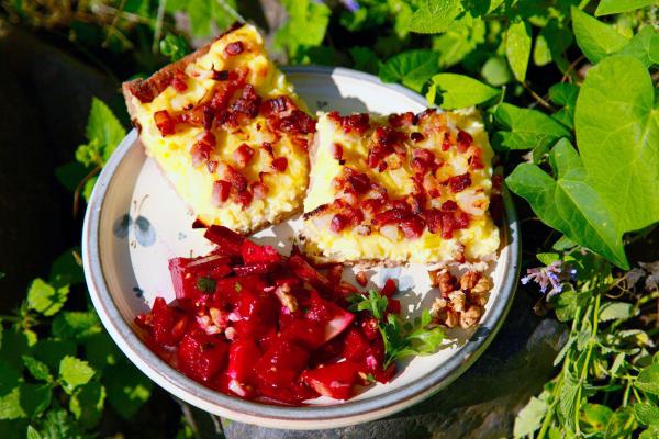 Bild 1 von 5: Zum Mittagessen gibt es Schmierschelkuchen, eine deftige Spezialität mit Kartoffelbrei, Schmand, Speck und Zwiebeln. Dazu wird Rote-Bete-Salat gereicht.