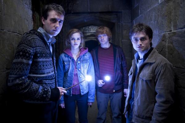 Bild 1 von 7: Matthew Lewis as Neville Longbottom, holding glowing wand, Emma Watson as Hermione Granger, Rupert Grint as Ron Weasley, holding glowing wand, and Daniel Radcliffe as Harry Potter