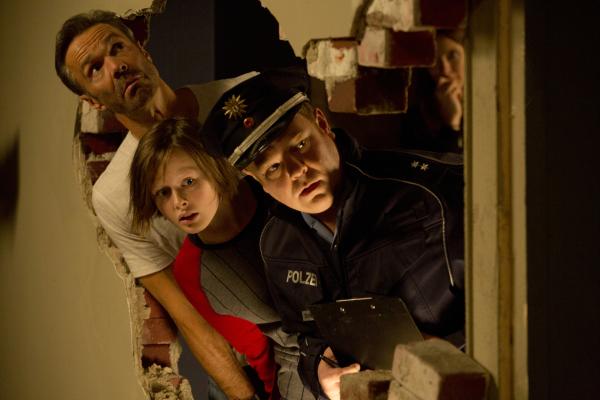 Bild 1 von 17: Der Polizist (Carsten Caniglia, r.) steht vor einem riesigen Problem: Nics (Lisa Bahati Wihstutz, M.) Vater Karl (Hannes Jaenicke, l.) hat ein Loch in die Wand zur Nachbarwohnung geschlagen - mit unerwünschten Aussichten ...
