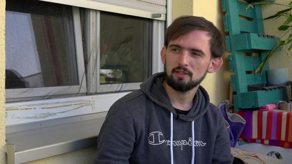 Bild 1 von 2: Jerrick hat nach zwei Jahren Obdachlosigkeit endlich eine eigene Wohnung und plant voller Vorfreude den Einzug.