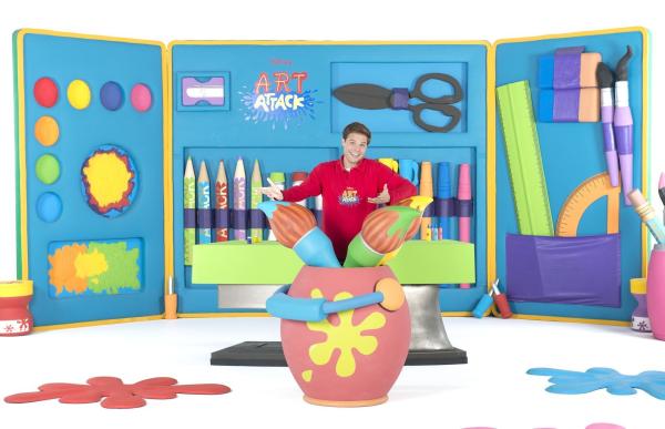 Bild 1 von 14: Stifte, Kleber, fertig, los! Das große Basteln beginnt wieder - mit brandneuen Folgen von Art Attack. Moderator Nicolás Artajo führt die kleinen Zuschauer in seine bunte Bastelwelt und verwandelt Alltagsgegenstände in tolle Kunstwerke. Er zeigt, wie man mit wenigen Hilfsmitteln wunderschöne Projekte umsetzt. Damit seine Zuschauer es ihm gleichtun können, wird jeder Handgriff genau erklärt. Schritt für Schritt zeigt Disney Art Attack, wie man aus unscheinbaren Haushaltsgegenständen wie leeren Küchenpapierrollen, Pappkartons, leeren Joghurtbechern und Zeitungspapier die tollsten Sachen zaubert. Dabei wird nicht nur die Fantasie der kleinen Zuschauer angeregt, auch die kreativen und motorischen Fähigkeiten werden gefördert. Nicolás hat sich auch für die elfte Staffel wieder einiges vorgenommen: Neben Big-Band-Instrumenten, einer Piratentaverne aus Holzstäbchen oder dreidimensionalen Hügelbildern und einem Lenker-Clown für den Roller oder das Fahrrad werden auch fliegende Topfpflanzen nachgebastelt.