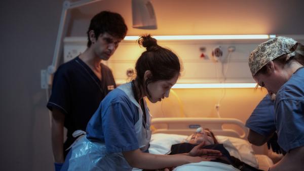 Bild 1 von 3: Als Adam (Ben Whishaw, l.) seine Patientin notgedrungen in das staatliche Krankenhaus einliefern muss, gibt es keine Zeit zu verlieren. Shruti (Ambika Mod, M.) übernimmt die Behandlung und Adam wird plötzlich etwas klar.