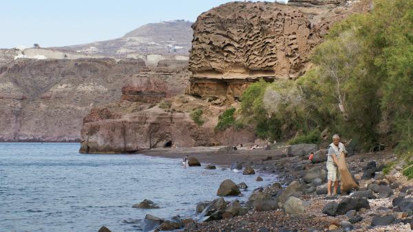 Bild 1 von 4: Strandreinigung am schwarzen Strand - mit spektakulärer Felsformationen imHintergrund.
