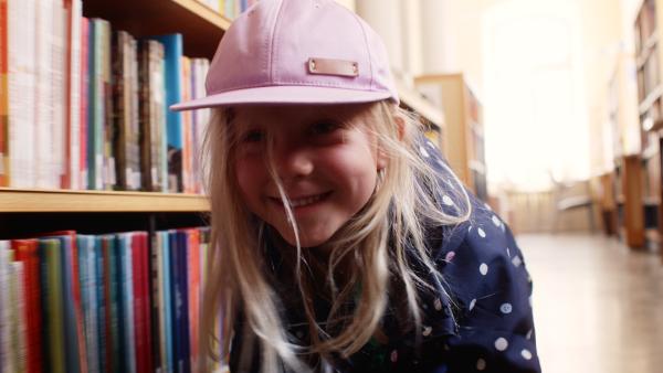 Bild 1 von 4: Vilda (Sofia Sittnikow) versteckt sich in der Bibliothek vor ihrem Vater.