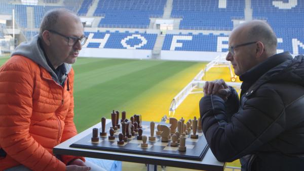 Bild 1 von 3: Der Denksport Schach hat viel mit Mathe zu tun. Von links: Prof. Dr. Christian Hesse (Professor für Mathematische Statistik an der Universität Stuttgart) und Wissenschaftsmoderator Karsten Schwanke in der Rhein-Neckar-Arena in Sinsheim, Heimstadion der TSG Hoffenheim.